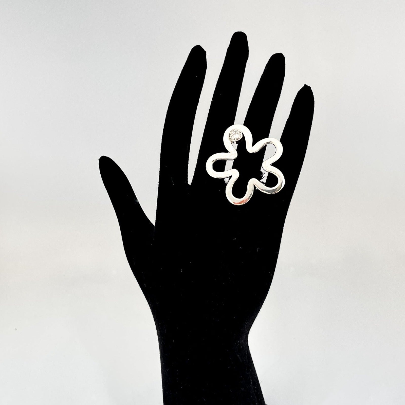 Elegant sterling silver floral ring showcased on a black mannequin hand, highlighting its delicate flower design.